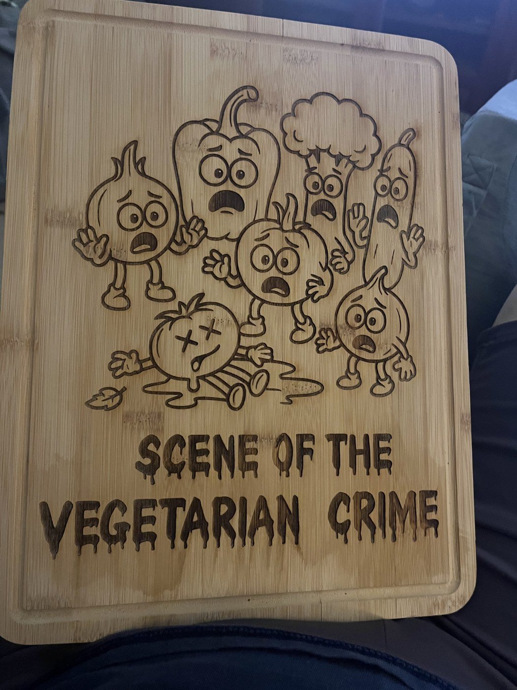 Wooden cutting board engraved with a playful vegetable illustration